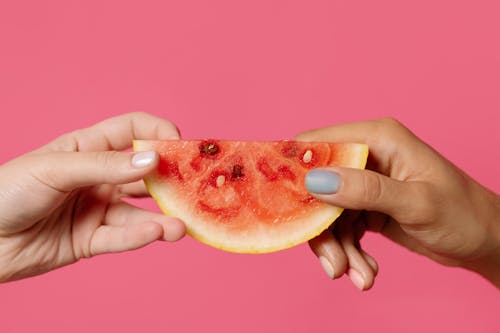 Person Holding Sliced of Watermelon