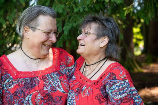 Portrait of Two People in Pattern Red Clothes Smiling