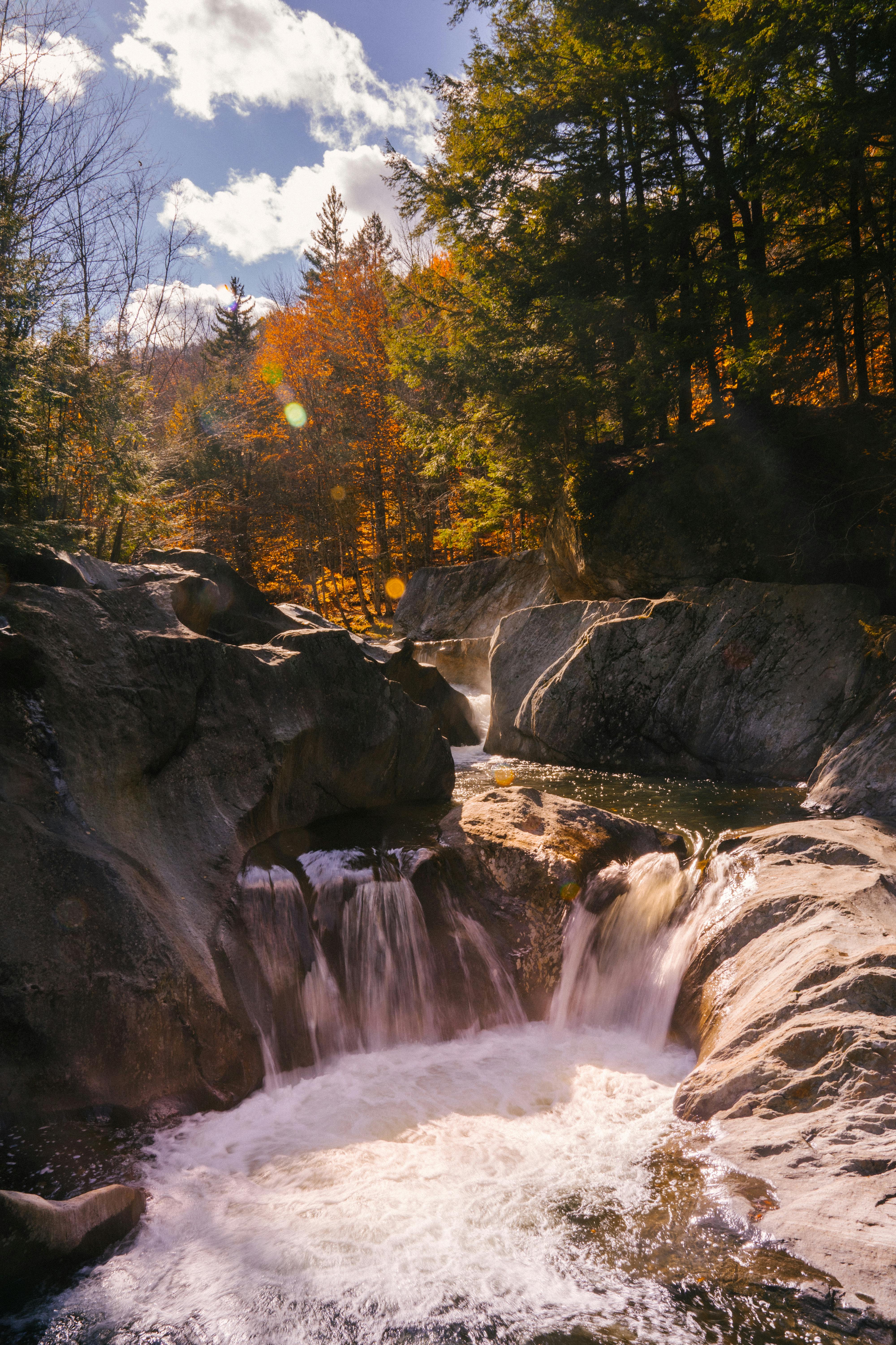 waterfall flowing among big rocks in autumn woods
