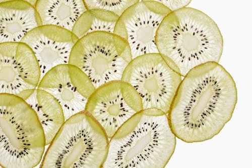 Close-Up Shot of Slices of Kiwi on a White Surface