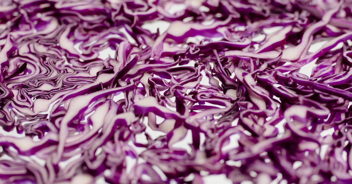 close up of hands massaging salt into shredded cabbage