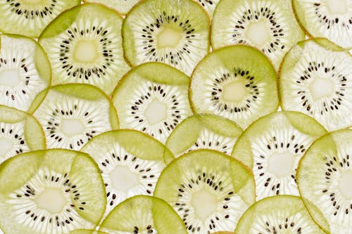 Close-Up Shot of Slices of Kiwi on a White Surface