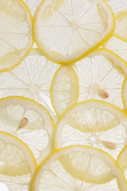 Close-Up Shot of Slices of Lemons on a White Surface