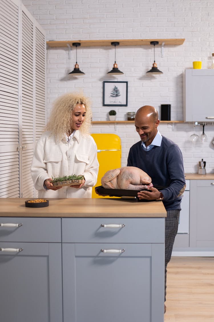 Cheerful Black Couple Cooking Turkey In Kitchen