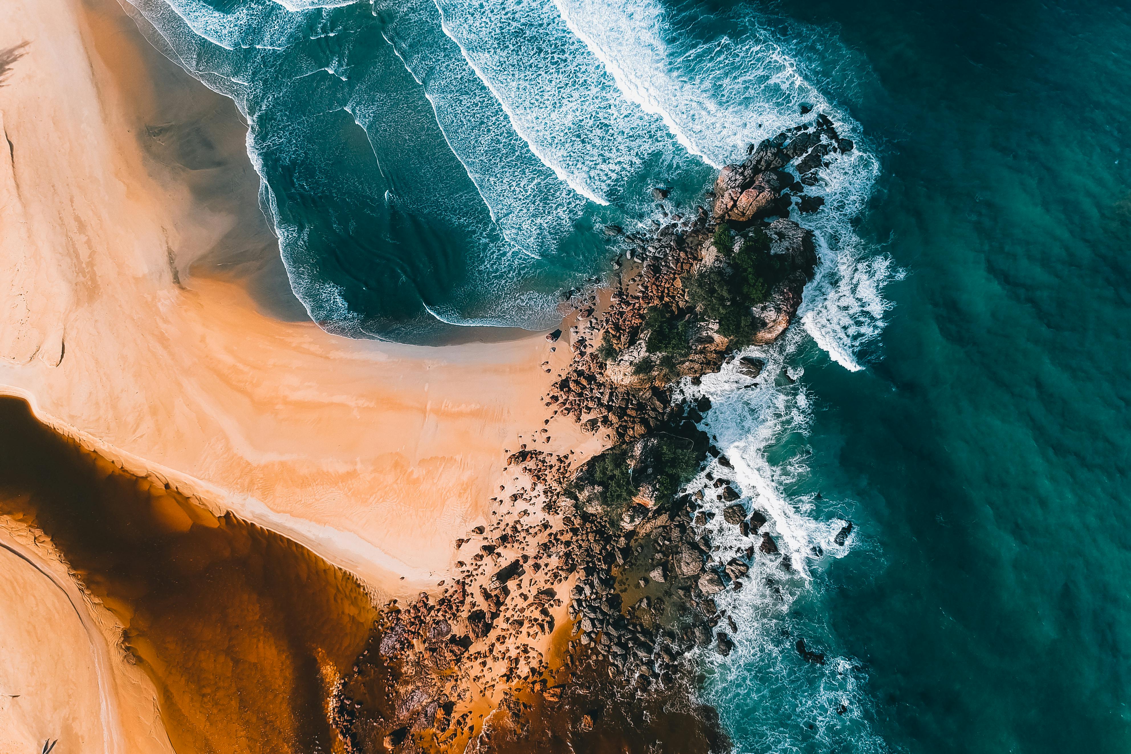 sandy coast with stones near foamy sea