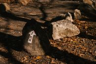Rough stones with arrow on dry terrain
