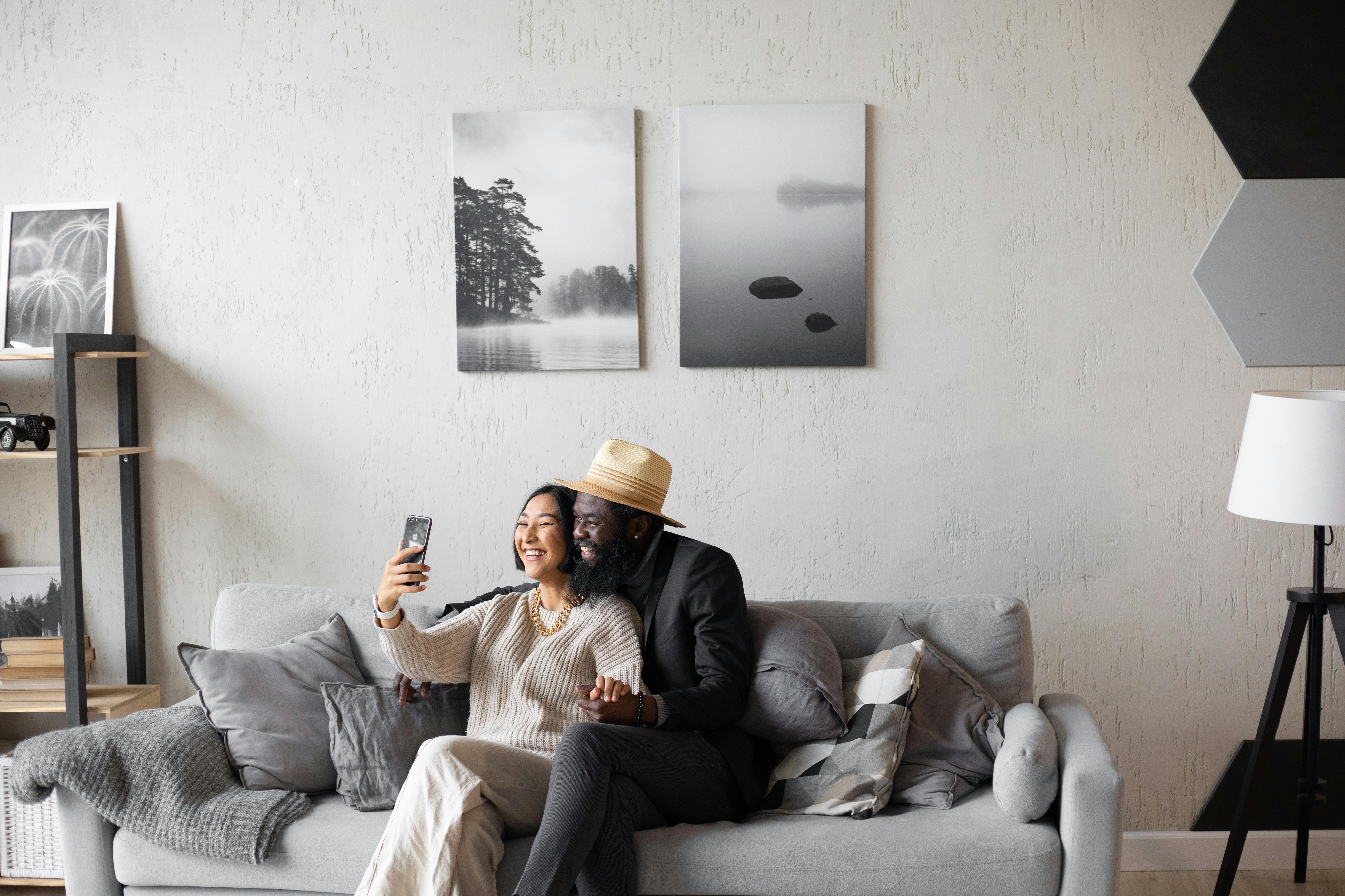 laughing multiethnic couple using smartphone while video chatting