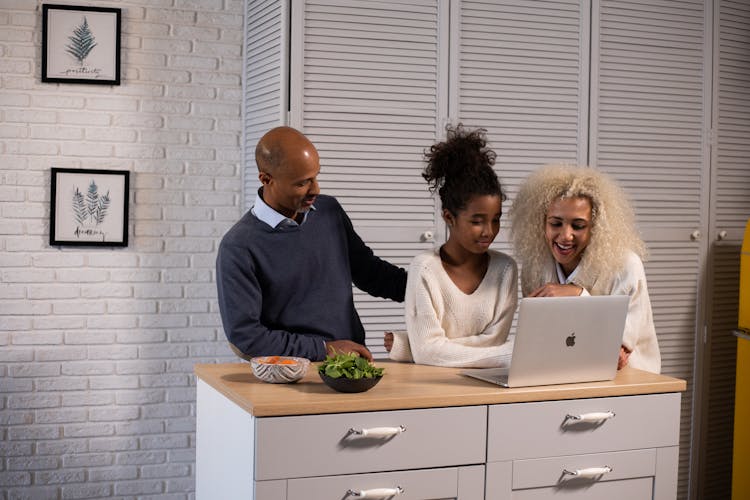 Cheerful Black Family Browsing Laptop