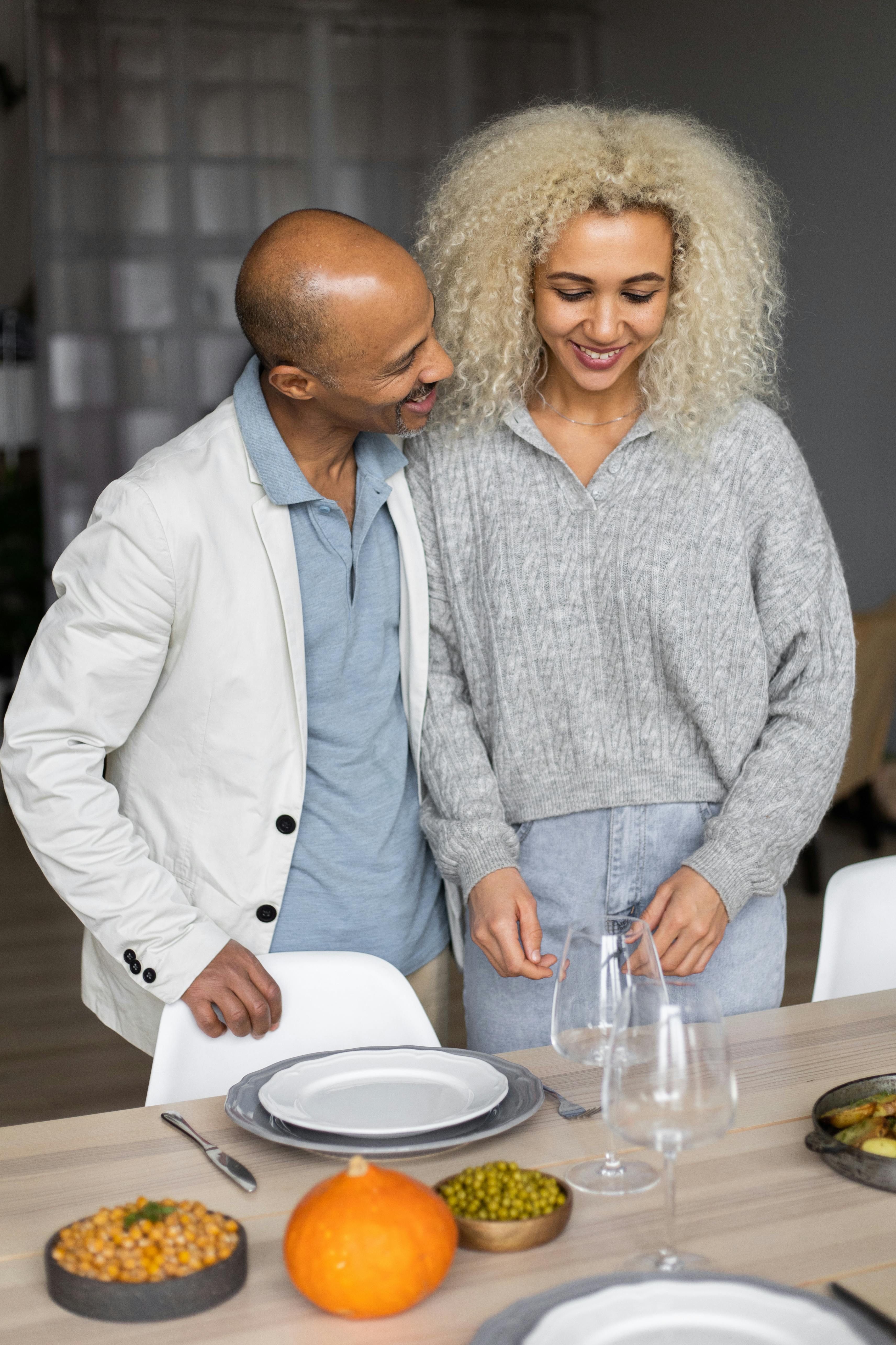 Cheerful diverse couple serving table