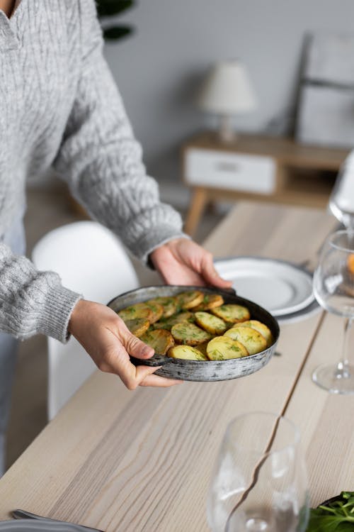 Crop woman serving table for dinner