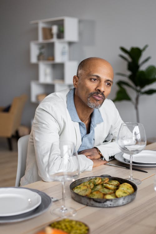 Serious ethnic man sitting at table