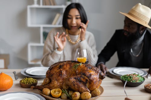 Diverse couple at table with turkey