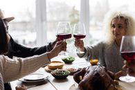 Multiethnic people clinking glasses having dinner