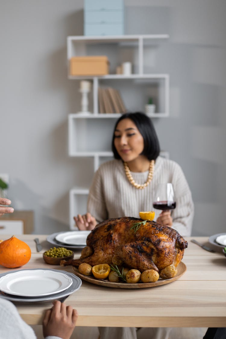 Ethnic Woman Having Dinner On Thanksgiving With Guests