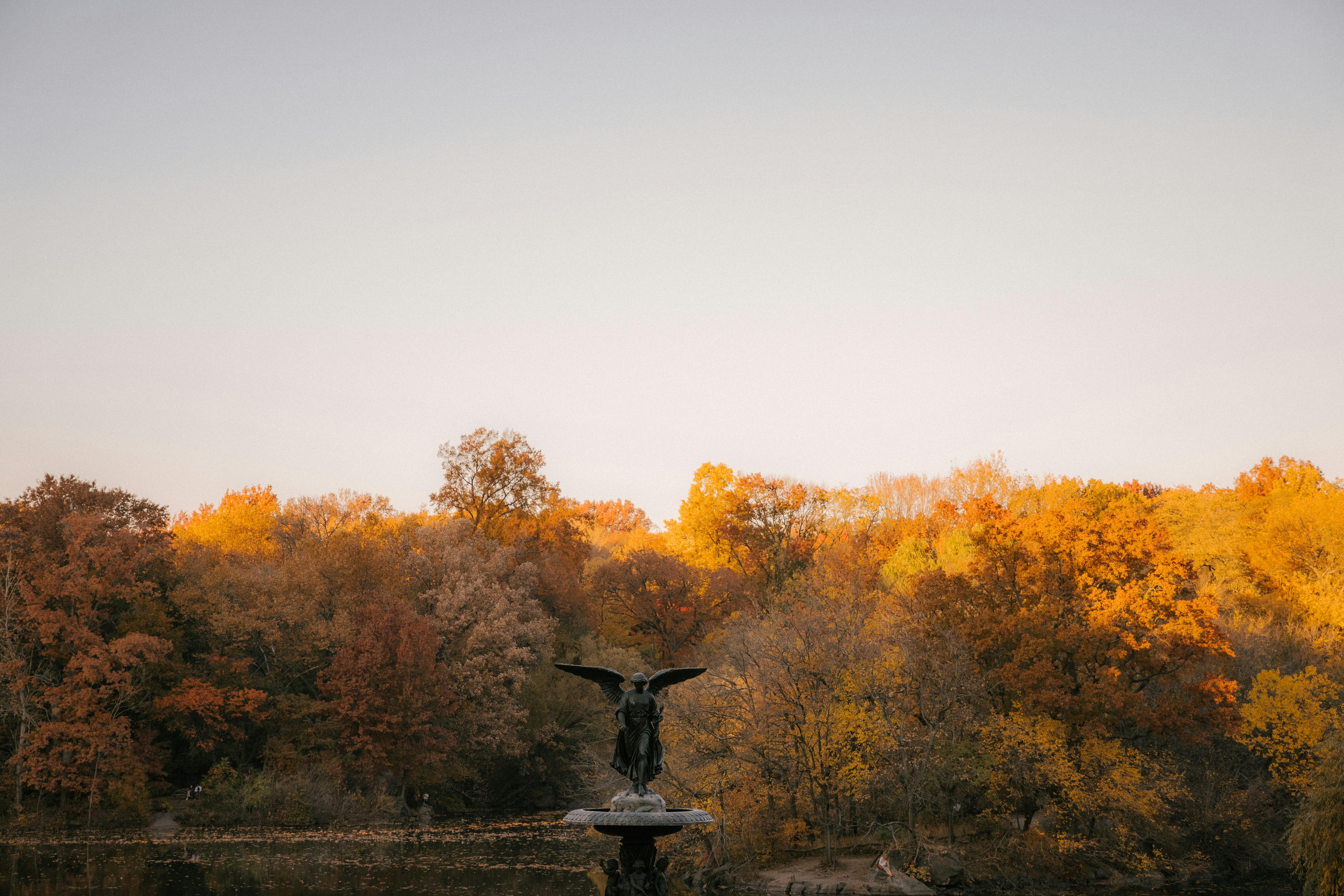 angel of the waters statue against autumn trees in daytime