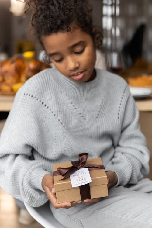 Calm black girl with gift box