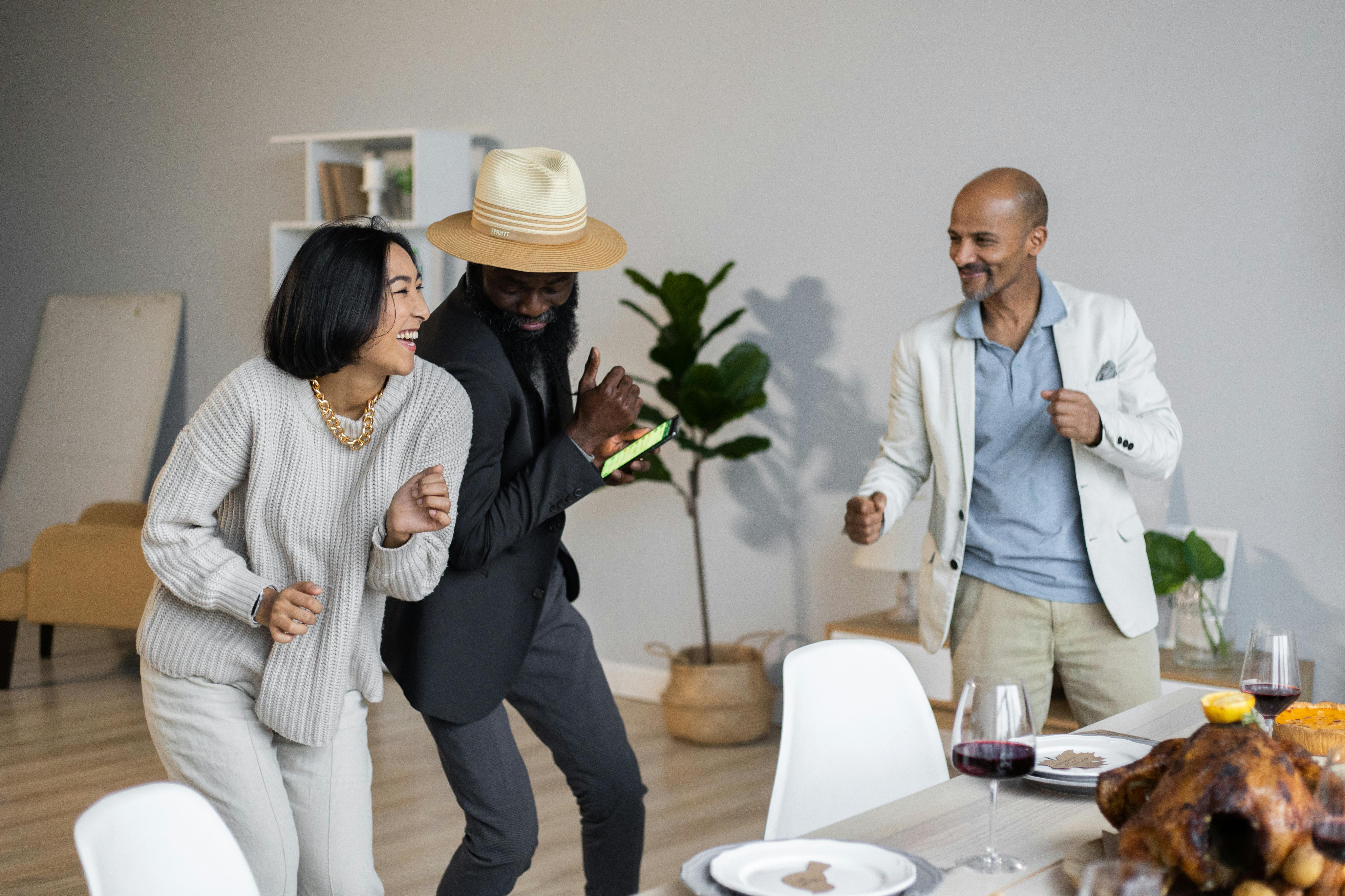 positive diverse friends dancing while celebrating thanksgiving