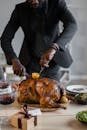 Crop black man cutting turkey in pieces