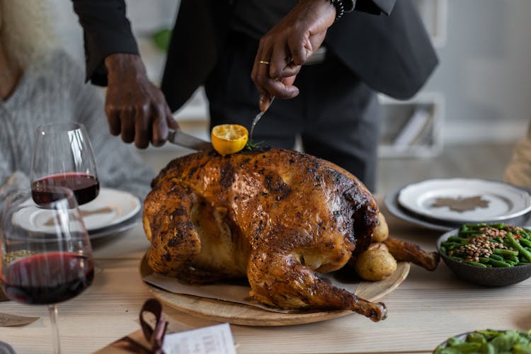 Crop Black Man Cutting Roasted Turkey