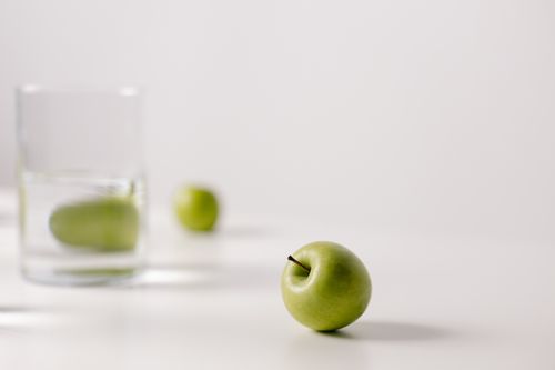 Green apple beside a glass of water