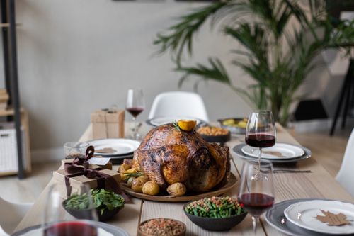 Free From above of palatable roasted turkey and glasses of wine on wooden table served for celebrating Thanksgiving Stock Photo