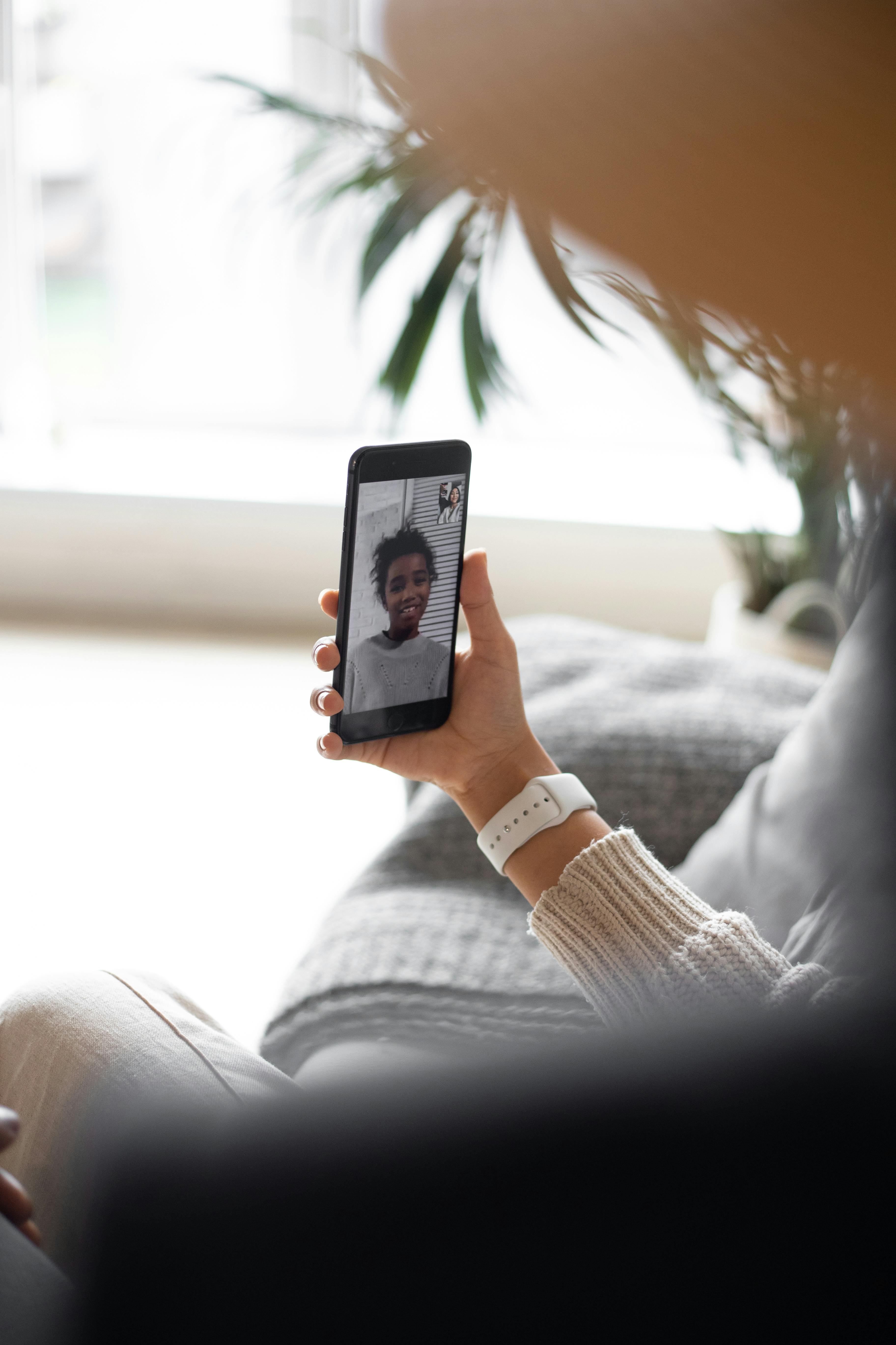 crop mother talking with black daughter via video call