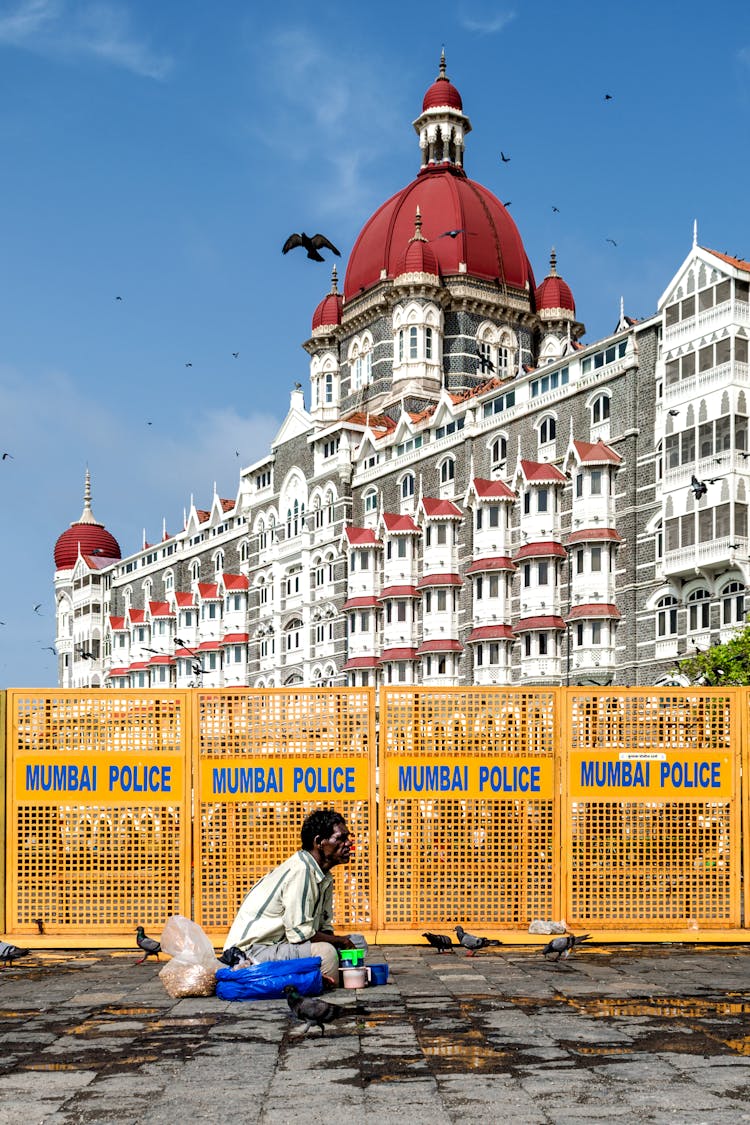 Person Sitting On The Ground Beside Barricade