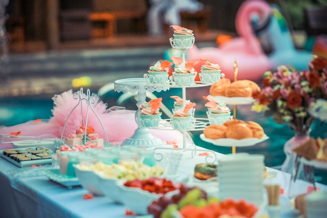 Colorful celebration table with cake, balloons, drinks, and decorative party details