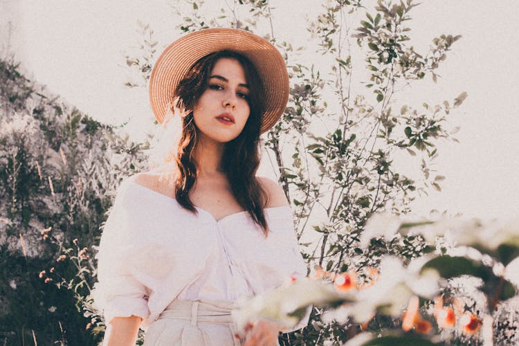 Beautiful Woman Wearing A Brown Sunhat Standing Near Plants