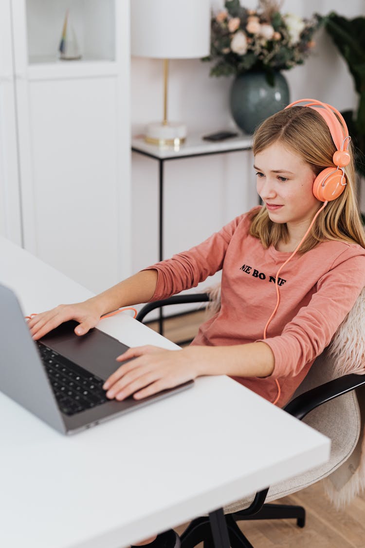 Girl Wearing Headphones While Using His Laptop