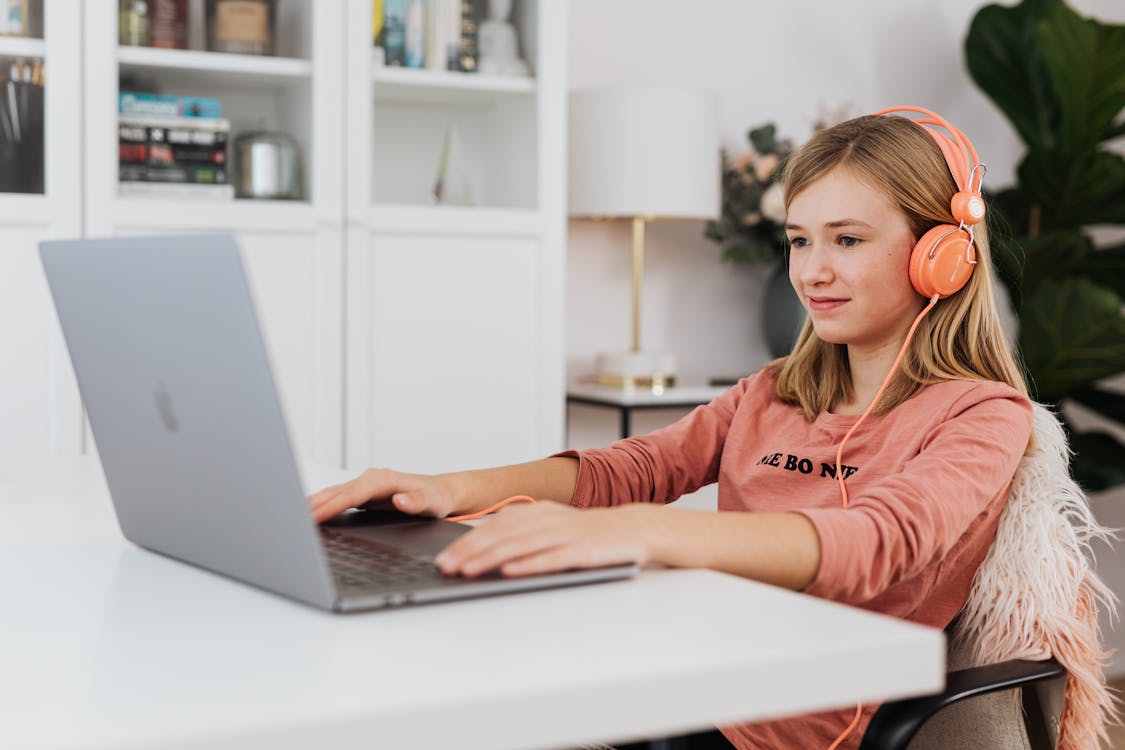 Woman in Pink Hoodie Using Macbook Pro