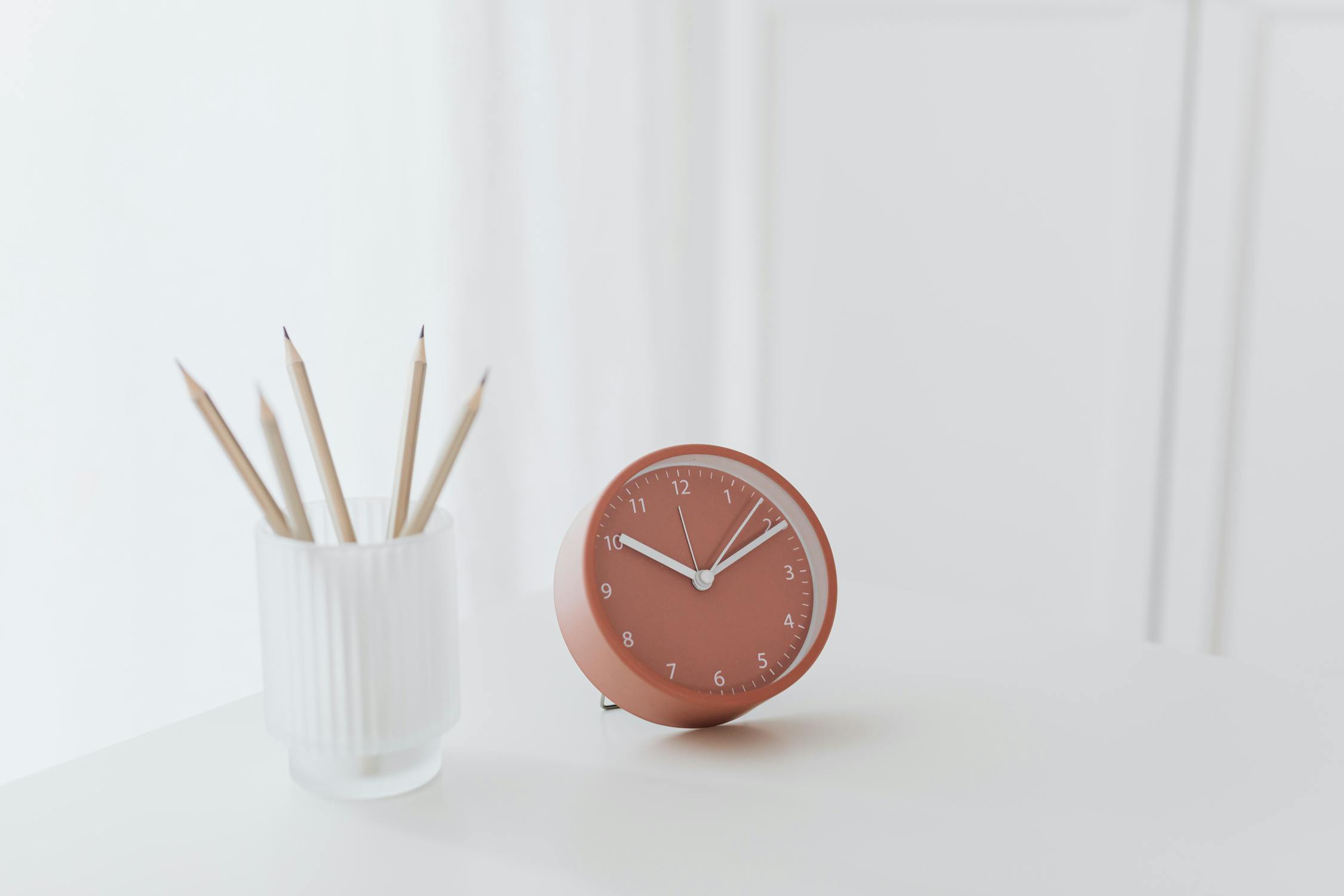 Peach clock on white table depicting 24 hour nature of customer support with conversational ai 