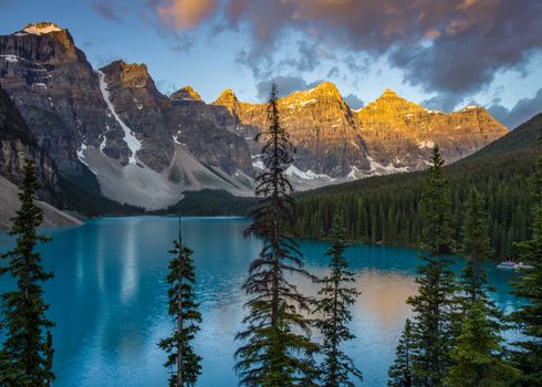 A stunning view of Moraine Lake with mountains at sunset in Banff National Park, Canada.