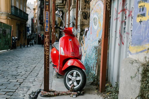 A Red Motor Scooter Parked on the Street