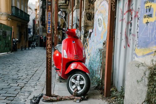 Free A vibrant red scooter parked on a cobblestone street in Istanbul, capturing the city's unique urban texture. Stock Photo