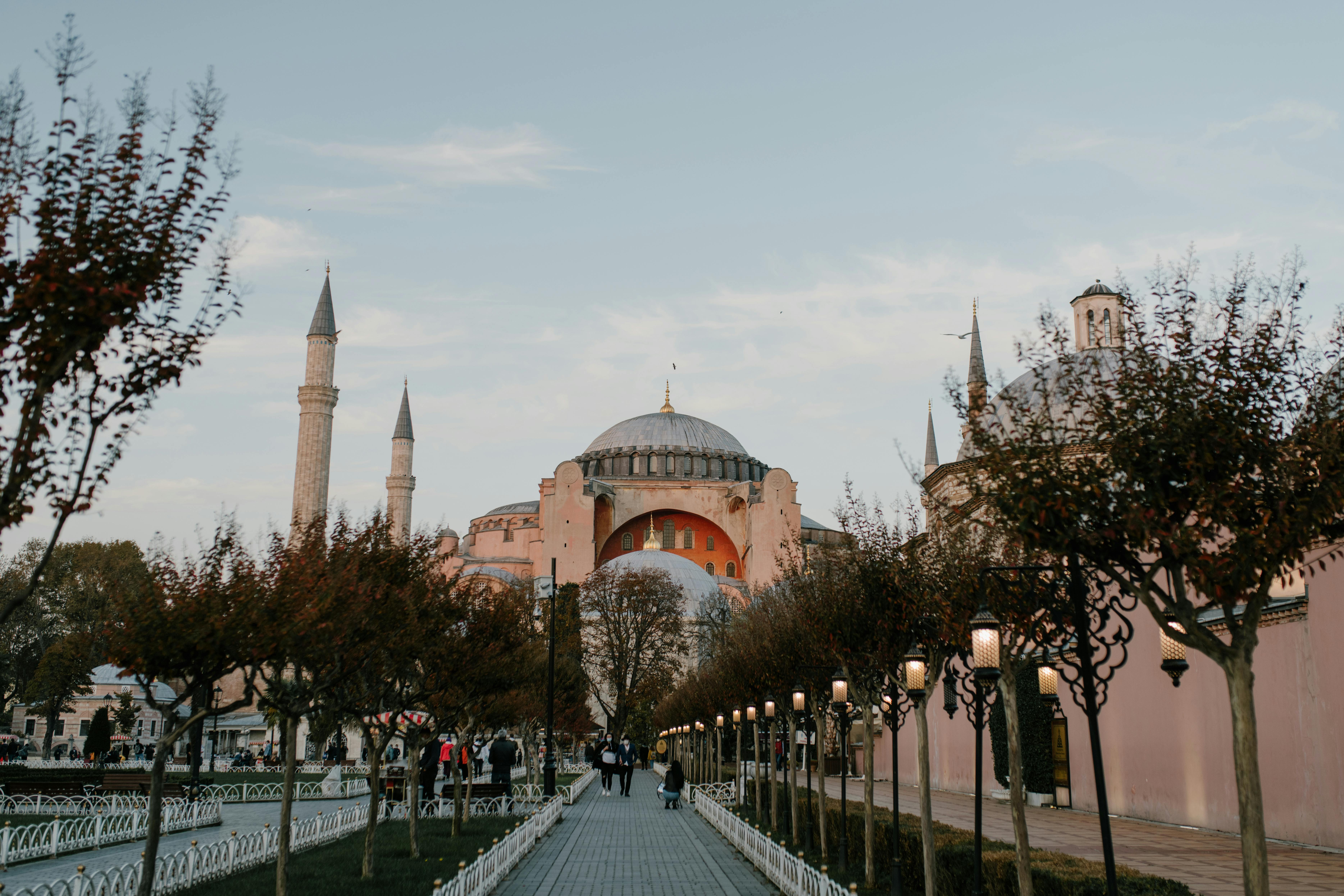 Les Gens Qui Marchent Sur La Rue Près Du Bâtiment En Béton Brun · Photo
