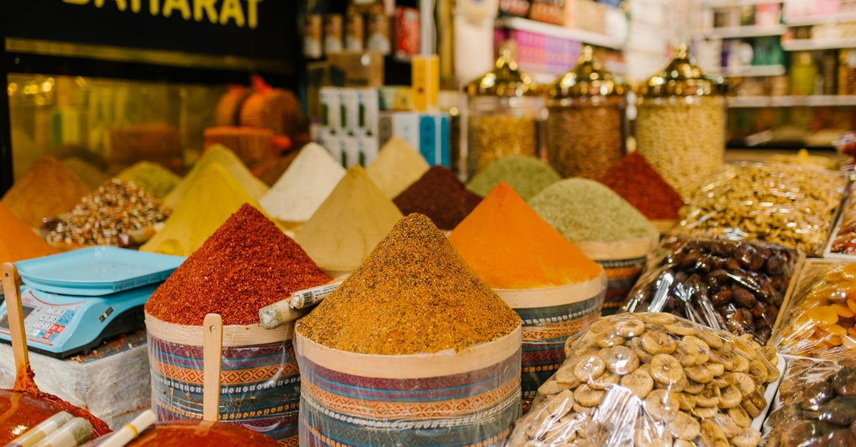 Colorful display of spices and dried fruits at a busy Istanbul market.
