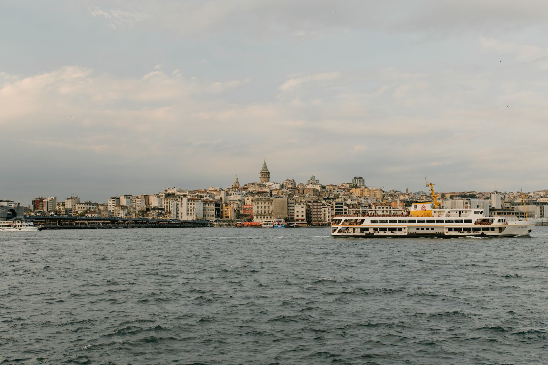 View of Istanbul's skyline and ferry with the iconic Galata Tower in the distance.