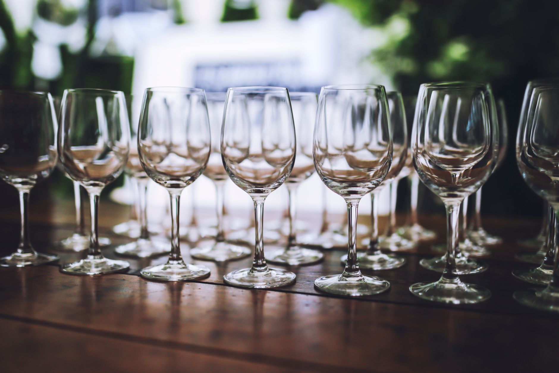 Elegant arrangement of wine glasses on a wooden table, perfect for celebrations and events.