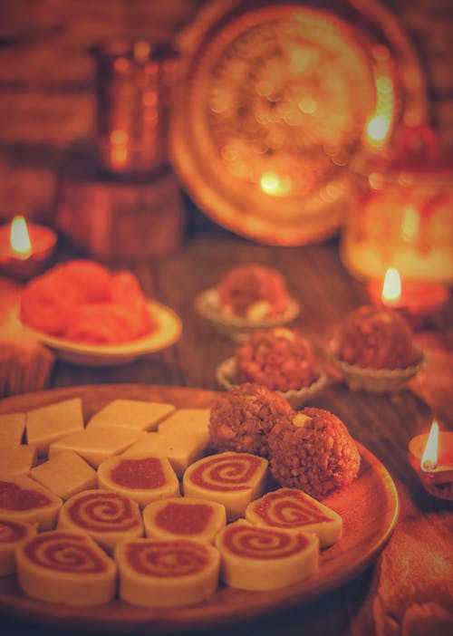 Free A Plate of Assorted Desserts on Wooden Table with Candle Lights Stock Photo