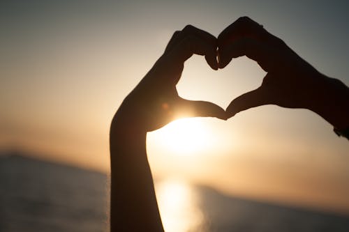 Free Person Rising Hands Forming Heart Silhouette Stock Photo