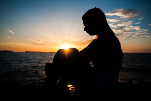 Silhouette of Person Sitting Outdoors