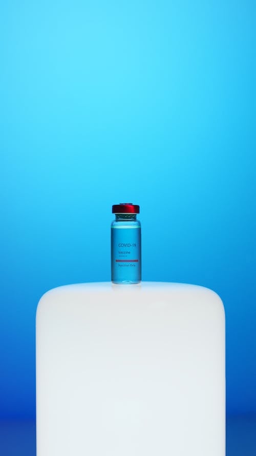 A Covid-19 Vaccine Vial on Blue Background