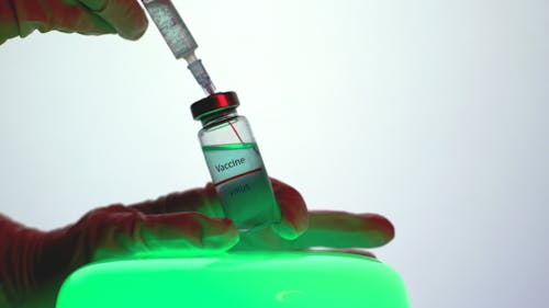 Free Person Aspirating the Vaccine from the Vial Stock Photo