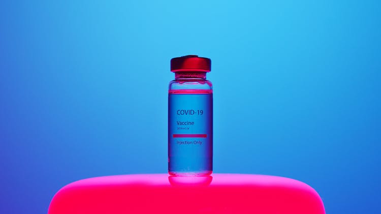 A Covid-19 Vaccine Vial On Blue Background