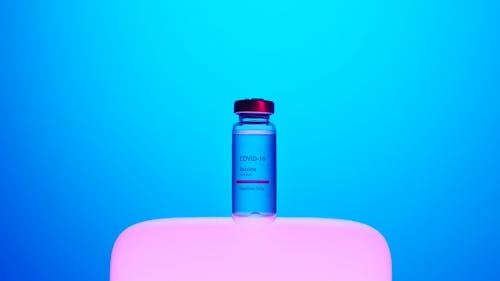 A Covid-19 Vaccine Vial on Blue Background