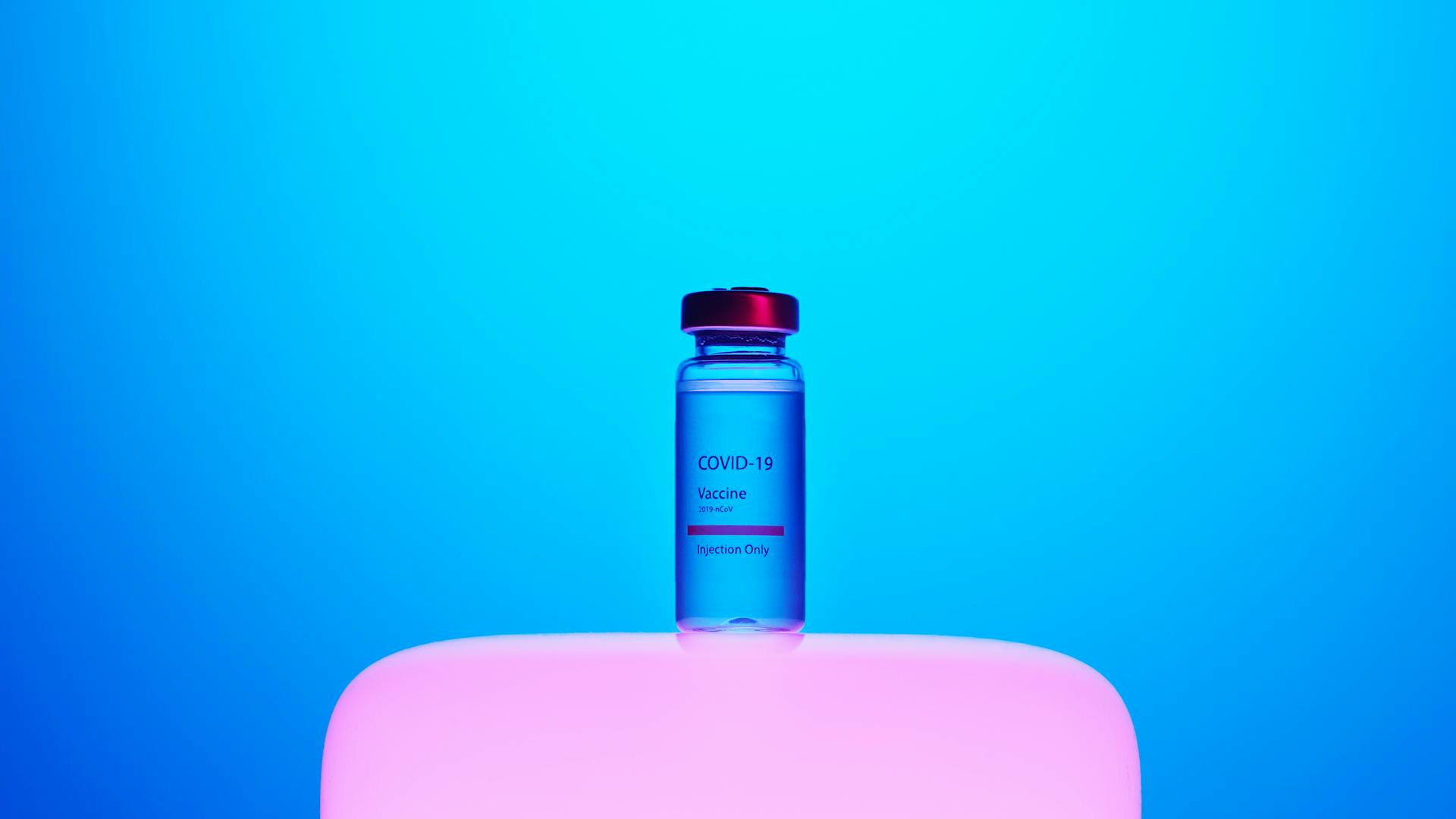 A Covid-19 Vaccine Vial on Blue Background