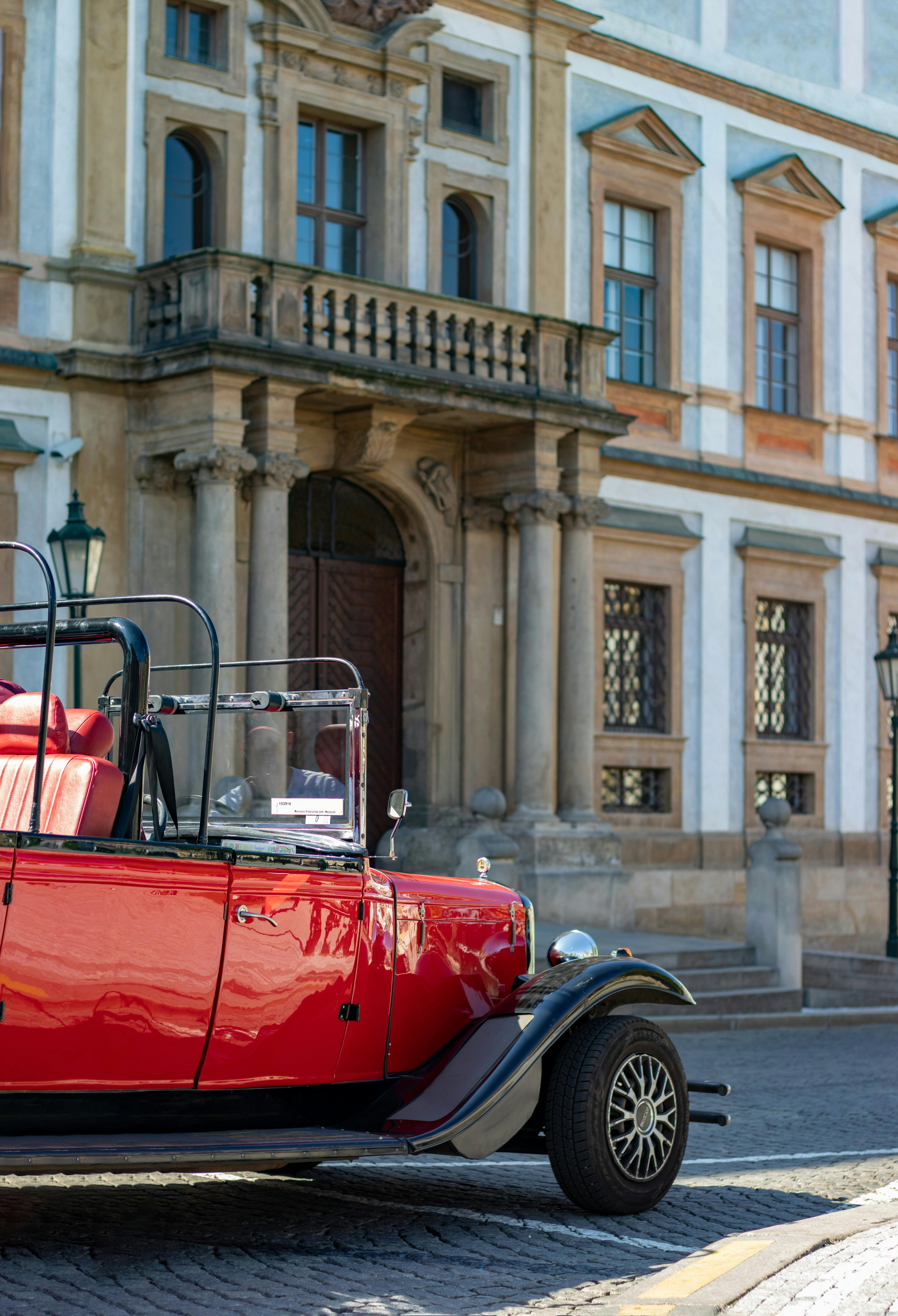 red and black vintage car on road