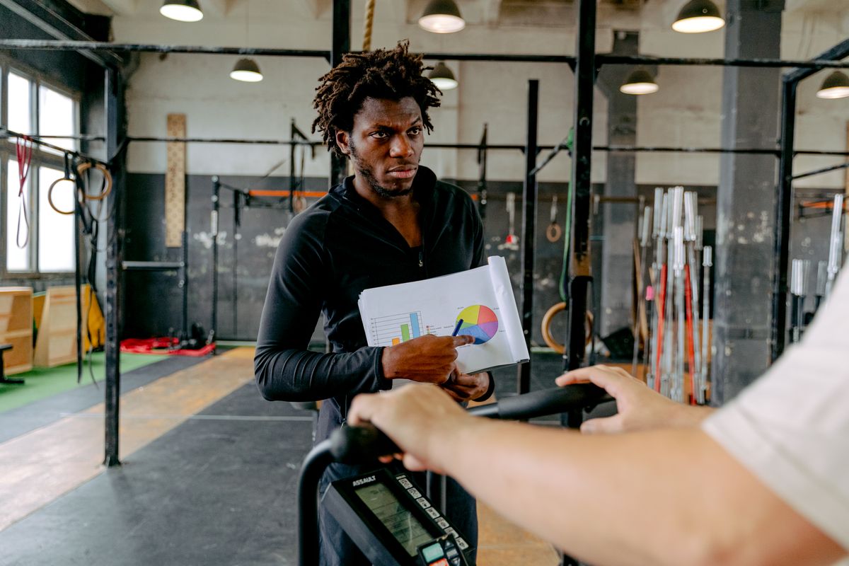 Personal trainer guiding a client at the gym