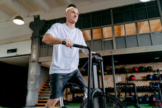 A determined man with a prosthetic leg exercising on a stationary bike in a gym setting.